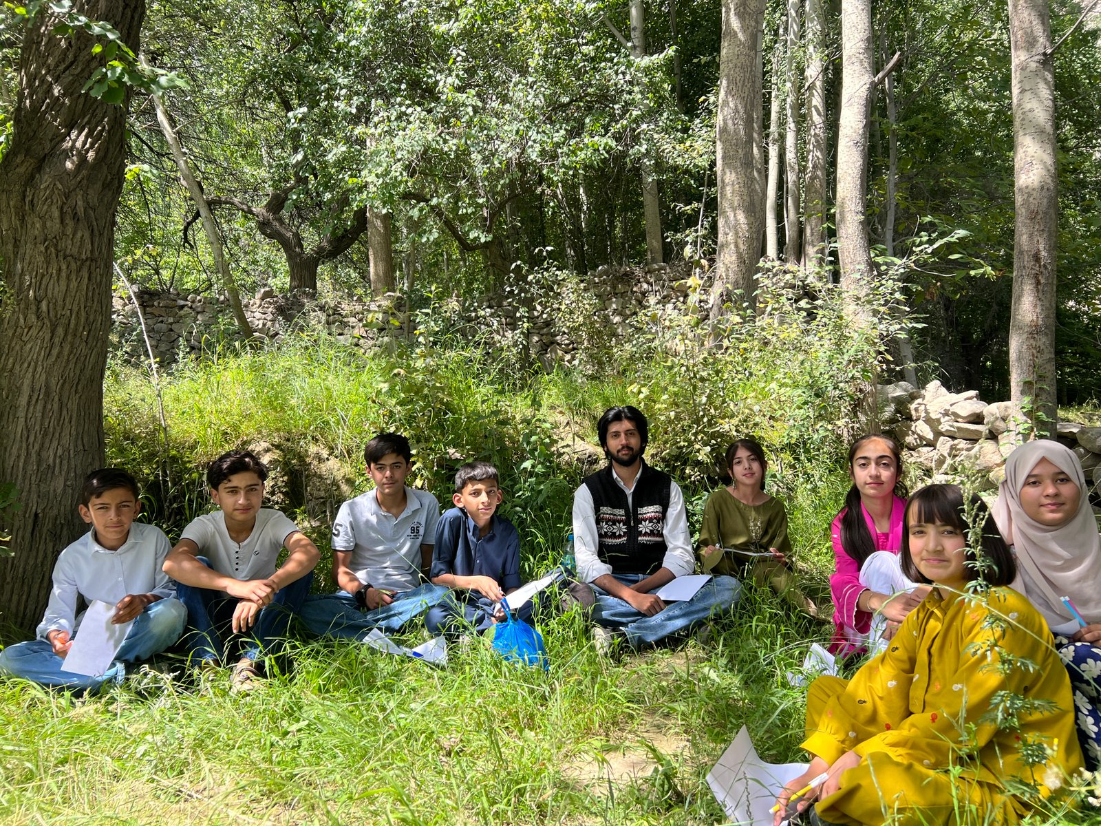 E47 Foundation students gathered outdoors during a class session in Hunza.